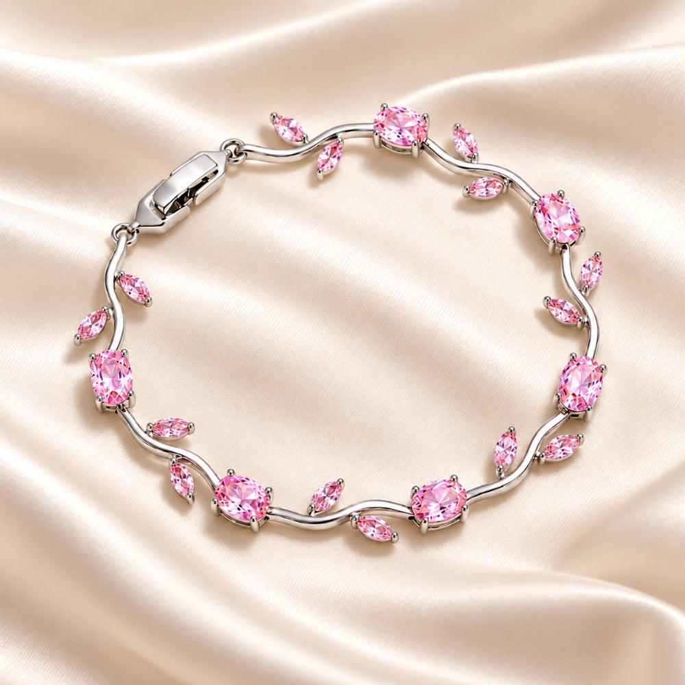 Elegant MARLA Fine Jewellery silver-tone bracelet featuring sparkling pink oval and marquise-cut gemstones in a delicate floral vine design on champagne satin.