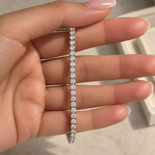 Silver 3mm moissanite tennis bracelet held by a model, showcasing brilliant round-cut stones and elegant craftsmanship.