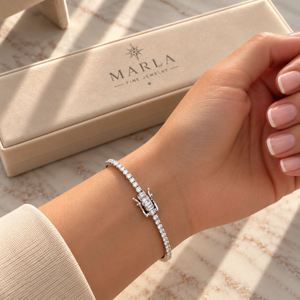 Silver moissanite tennis bracelet worn on a woman's wrist beside MARLA luxury jewellery gift box.