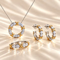 MARLA Celia Jewellery Set featuring a sparkling moissanite ring, circular pendant necklace and matching hoop earrings with two-tone silver and gold accents on luxurious champagne silk.