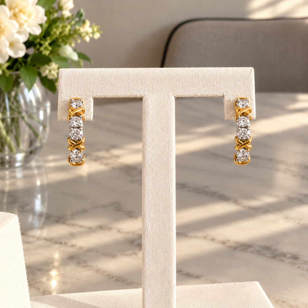 Celia Moissanite Hoop Earrings displayed on a cream jewellery stand, showcasing brilliant moissanite stones and elegant two-tone silver and gold detailing.