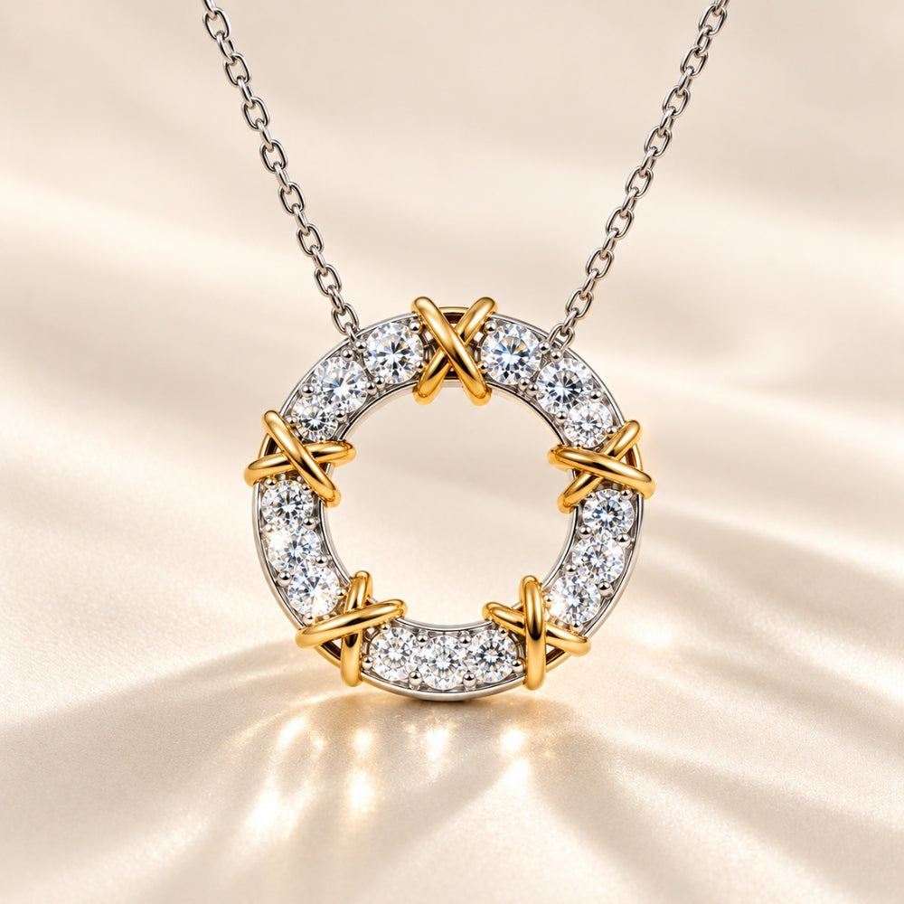 MARLA Celia Necklace featuring a circular moissanite pendant in 925 sterling silver with gold X-shaped accents and sparkling round stones, displayed on a luxury cream satin background.