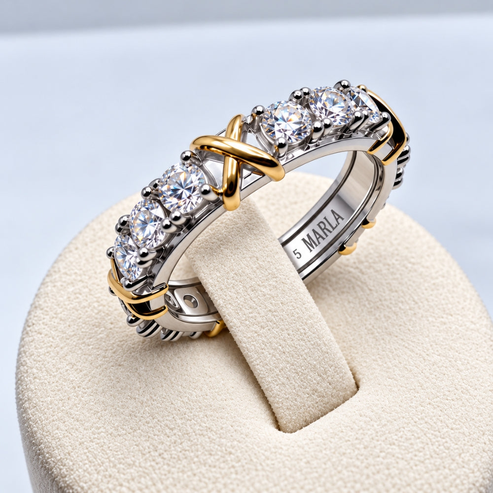Close-up of the Celia 1.5ct Moissanite Ring by MARLA, highlighting gold-tone X accents, brilliant stones and engraved band.