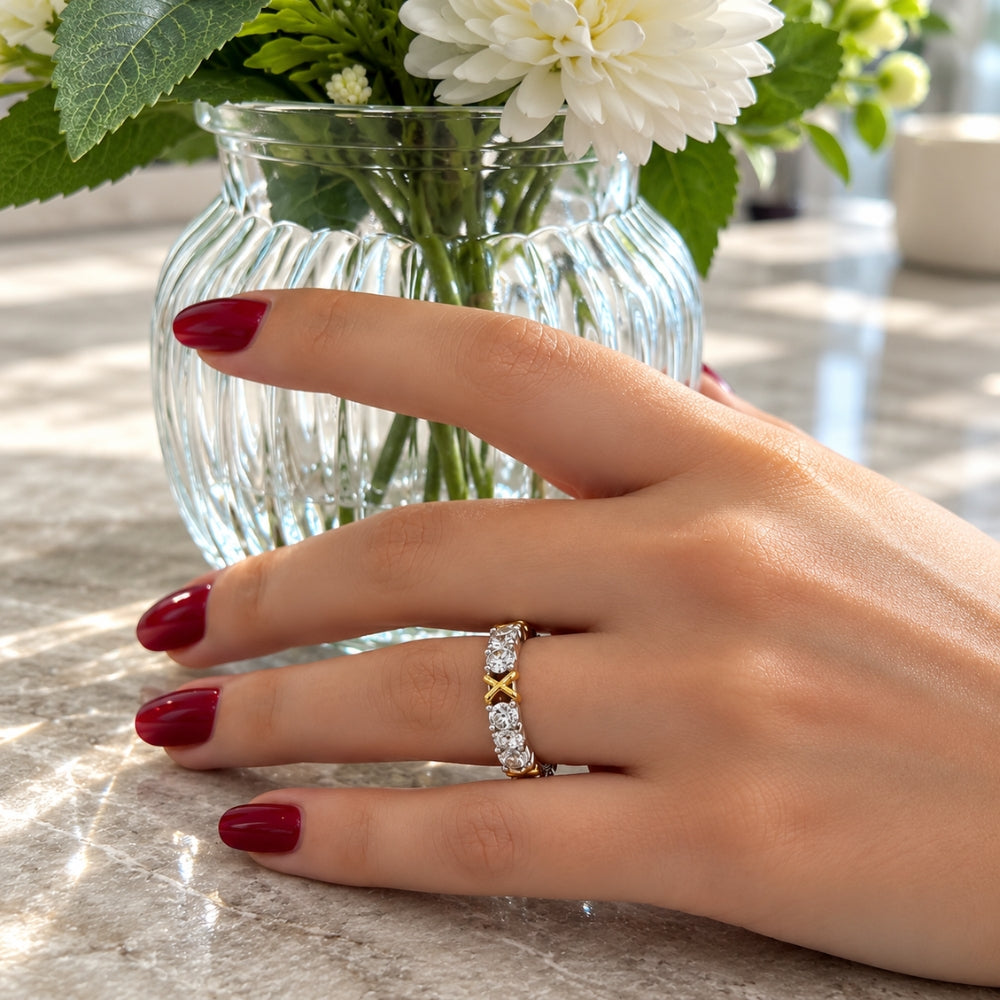 MARLA Celia 1.5ct Moissanite Ring with sparkling stones and gold-tone accents, styled on a woman's hand with burgundy nails.