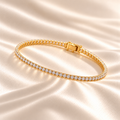 Marla Jewellery 2mm Moissanite Tennis Bracelet in gold-finished 925 sterling silver, featuring delicate round-cut moissanite stones in a single-row setting, elegantly displayed on champagne satin.