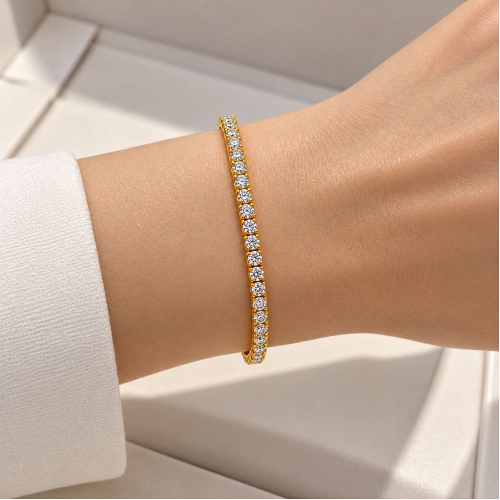 Gold 3mm moissanite tennis bracelet worn on a woman's wrist, featuring brilliant round-cut stones in an elegant setting.