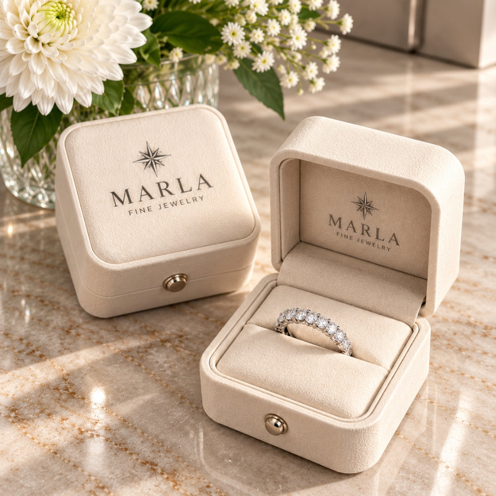 Marla Jewellery Moissanite Eternity Ring displayed inside an elegant cream branded jewellery box, surrounded by white flowers on a marble surface.