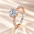 Rose Light Ring by Marla Jewellery featuring a sparkling 1ct round-cut moissanite center stone, two-tone rose gold and silver detailing, and an elegant 925 sterling silver band on a luxurious champagne satin background.
